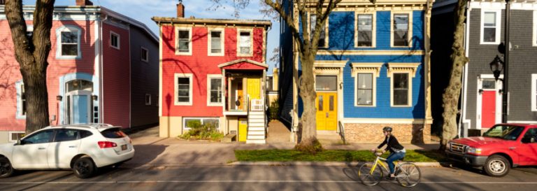 4 colourful Halifax homes and a cyclist biking past them