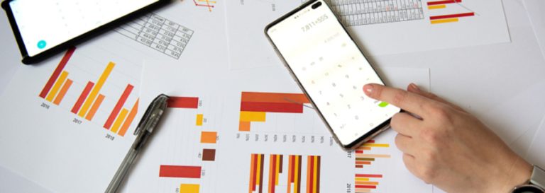 phone calculator laying on top of paper with graphs