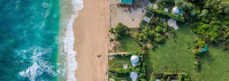 Aerial view of ocean, beach and home