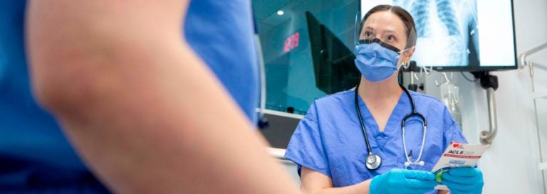 Healthcare worker in scrubs with mask