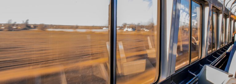View of fields through the windows of a train