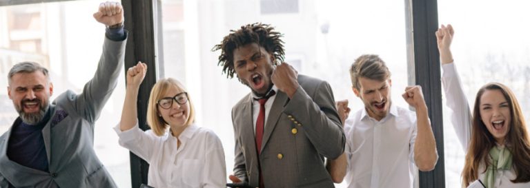 5 coworkers celebrating with fists in the air