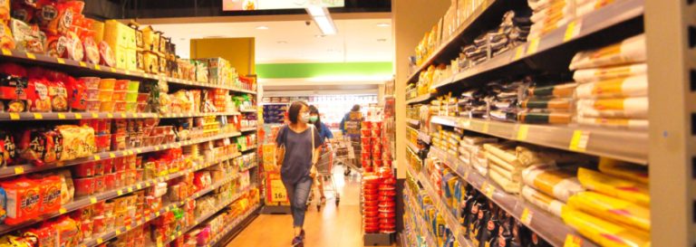 woman in mask walking through grocery store