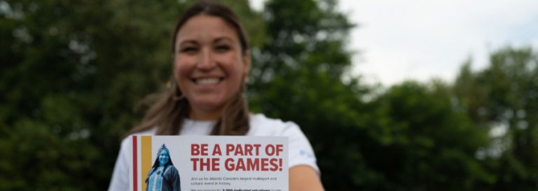 Woman holding up poster the reads "Be a part of the games"